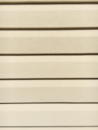 Team members carefully installing siding on a commercial property in Sandy, Utah.