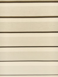 Hands fitting siding panels smoothly on a residential home exterior.