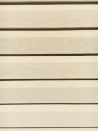 Horizontal beige siding panels with a textured surface. The panels are evenly spaced and aligned, providing a uniform appearance.