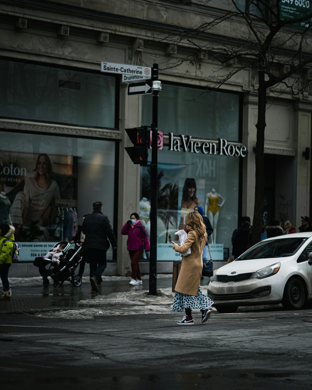 people walking on sidewalk near cars parked on sidewalk during daytime