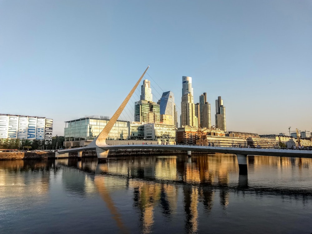 bridge over river near city buildings during daytime