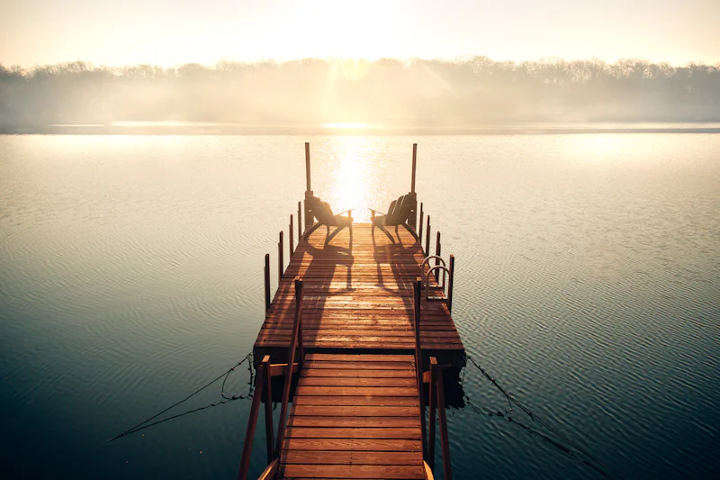 Brown wooden dock on a body of water during the day