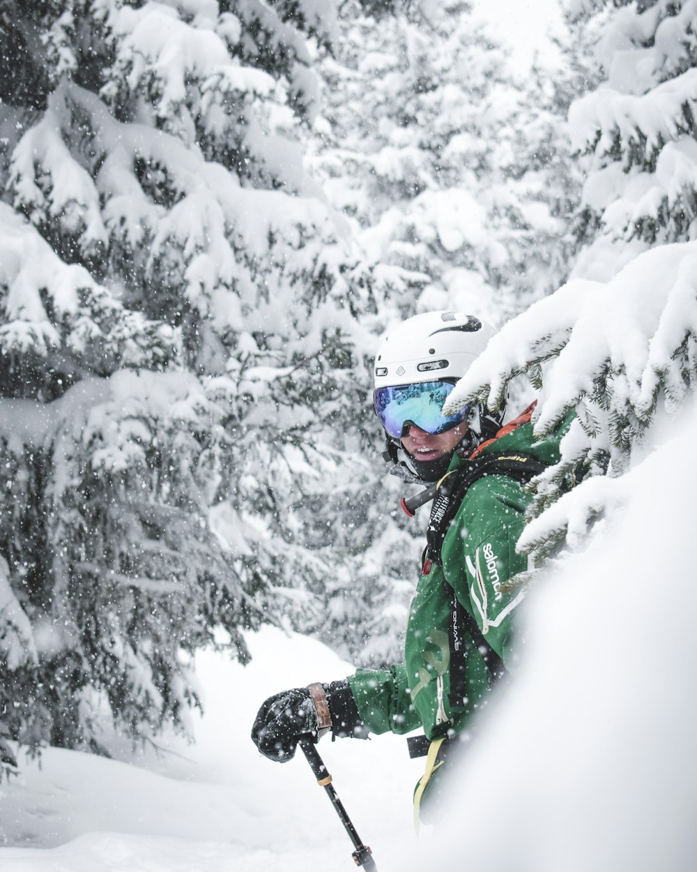 person in green jacket and black pants on snow covered ground during daytime