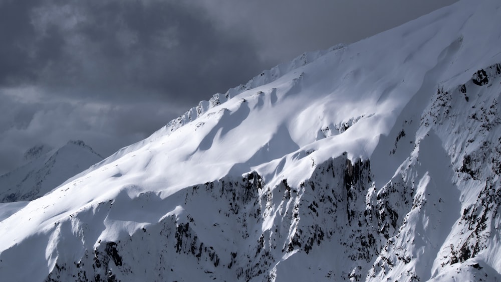 snow covered mountain under cloudy sky