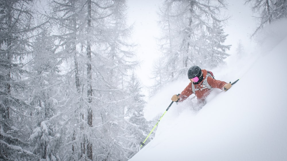 person in red jacket and black pants riding on ski blades on snow covered ground during