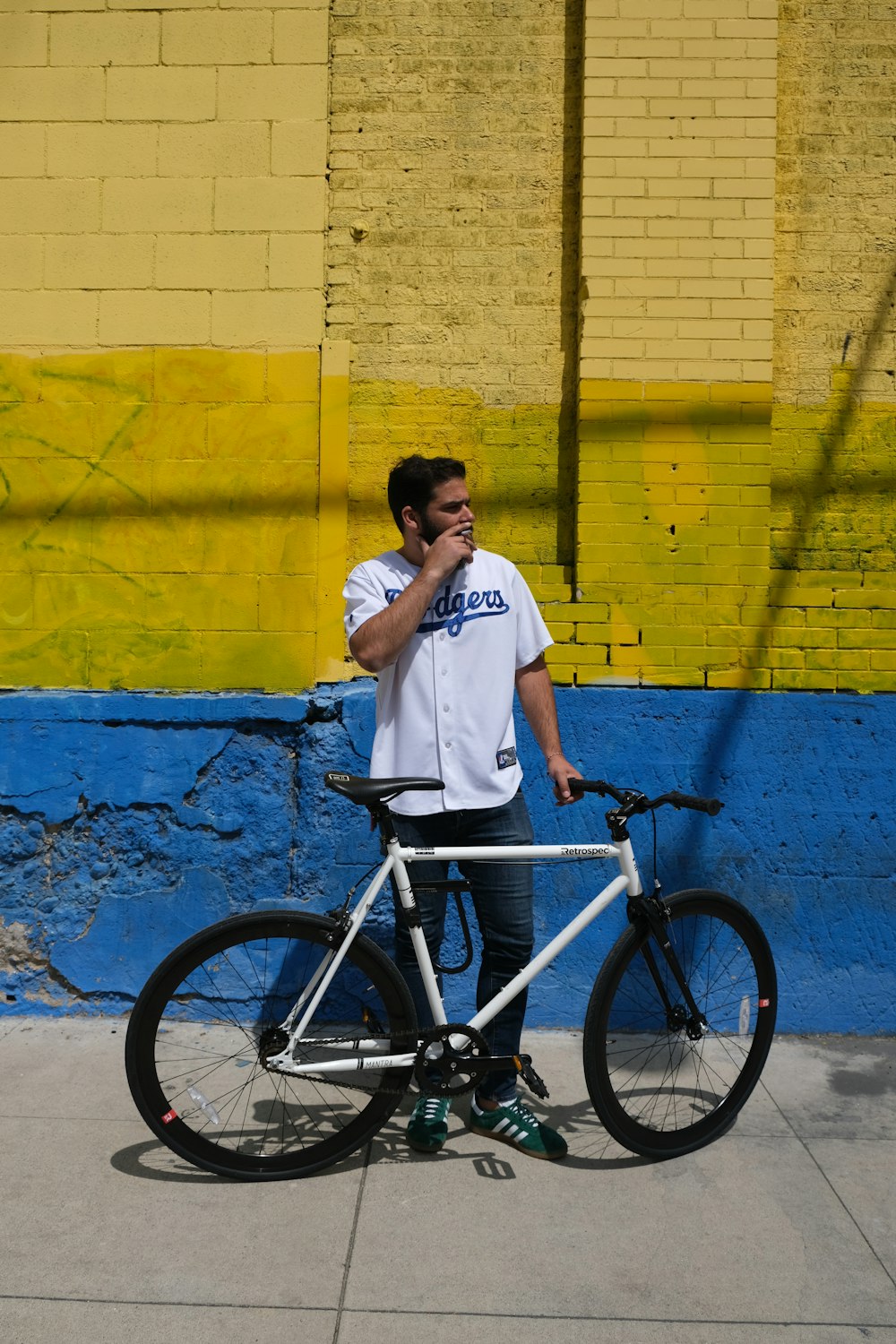 man in white shirt and black pants riding on black bicycle