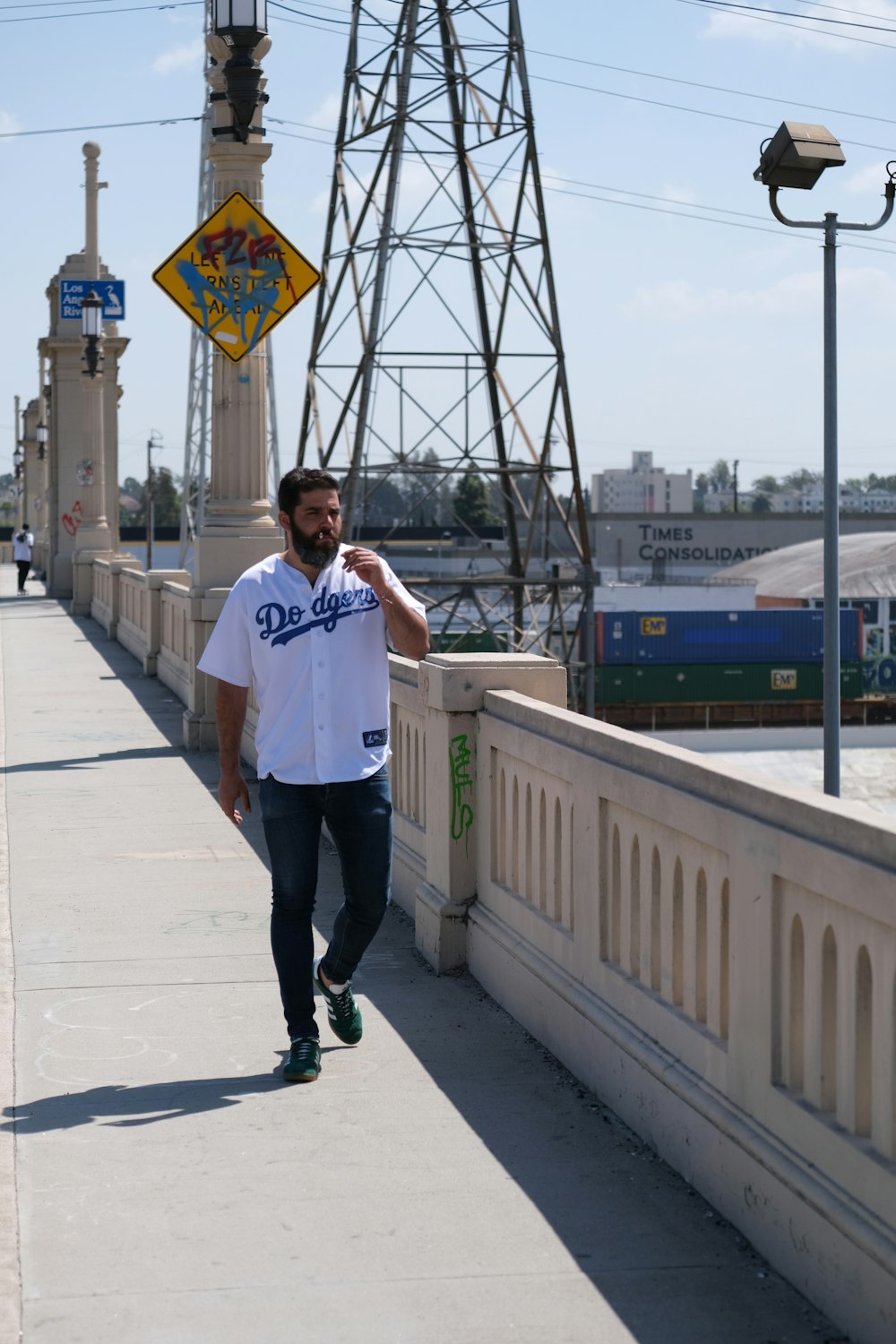 man in white button up shirt and black pants standing on gray concrete bridge during daytime