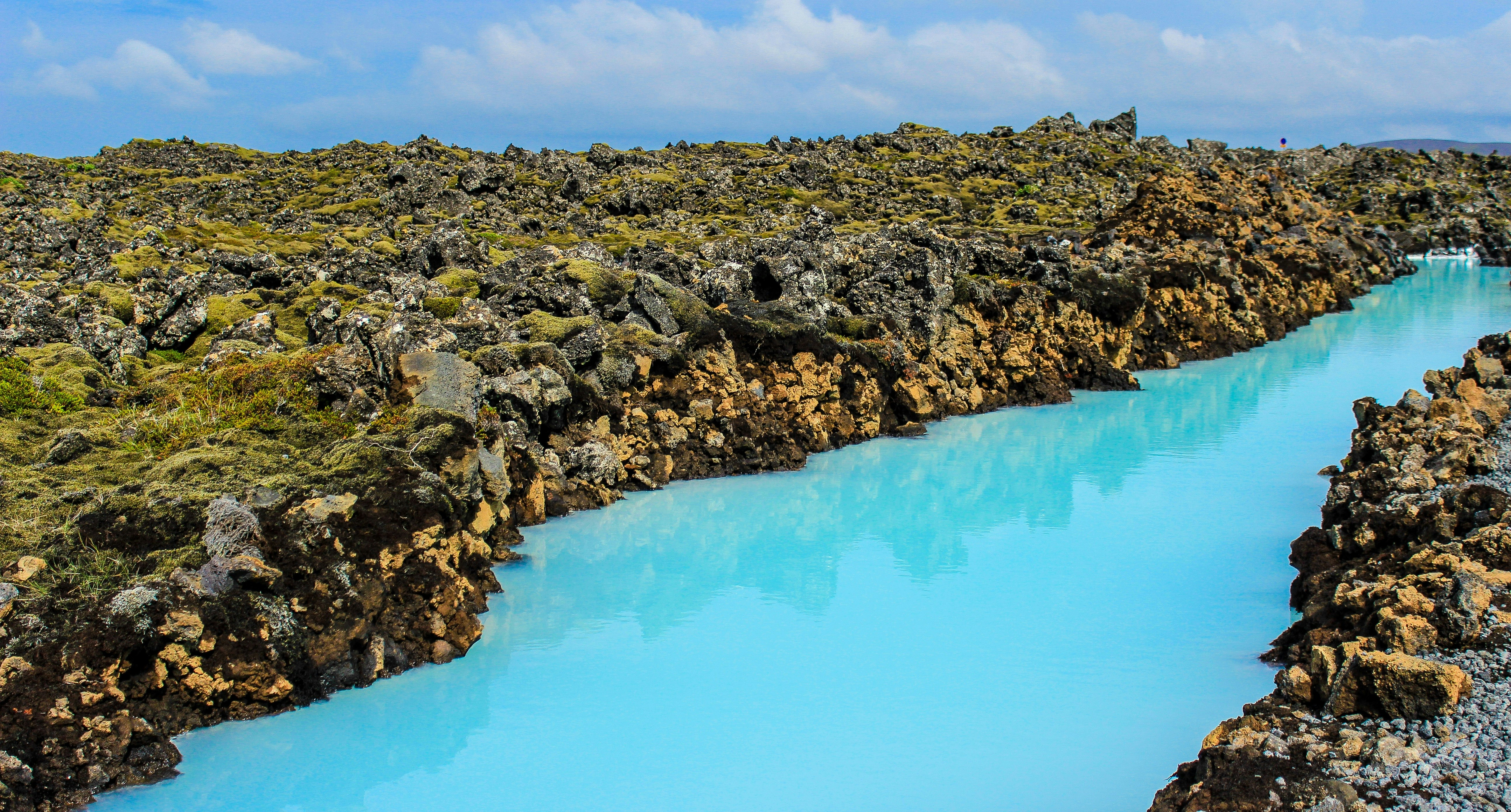 blue lake surrounded by green and brown rocks, The Blue river on Mars.