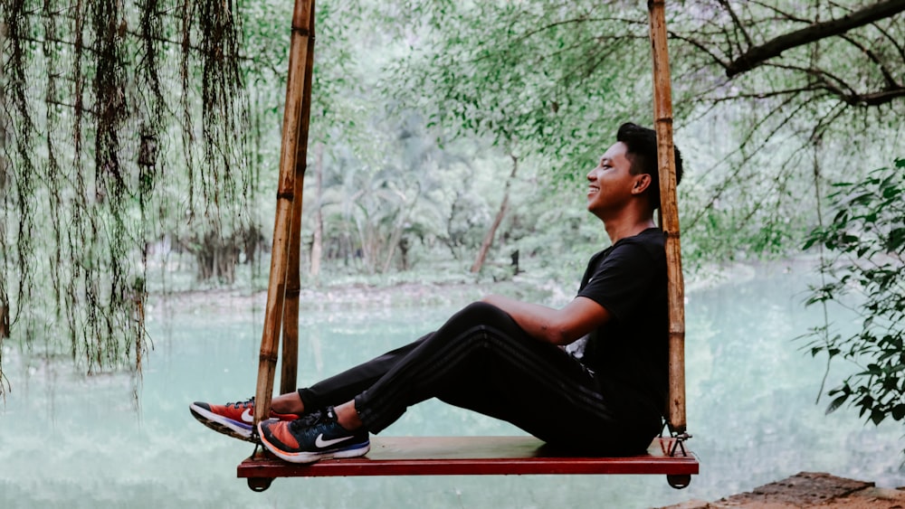 woman in black shirt sitting on red and white boat