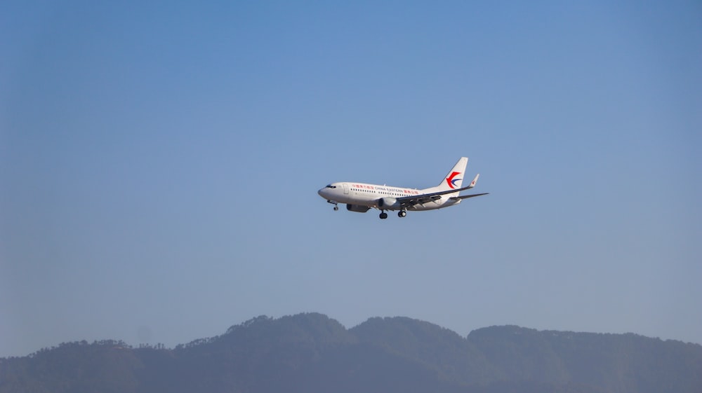 white and red passenger plane flying during daytime