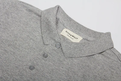 A sleek grey polo shirt with a small embroidered emblem on the sleeve.