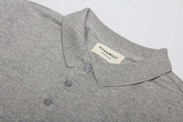 A polo shirt laid out on a natural linen surface, highlighting its breathable texture and soothing tones.