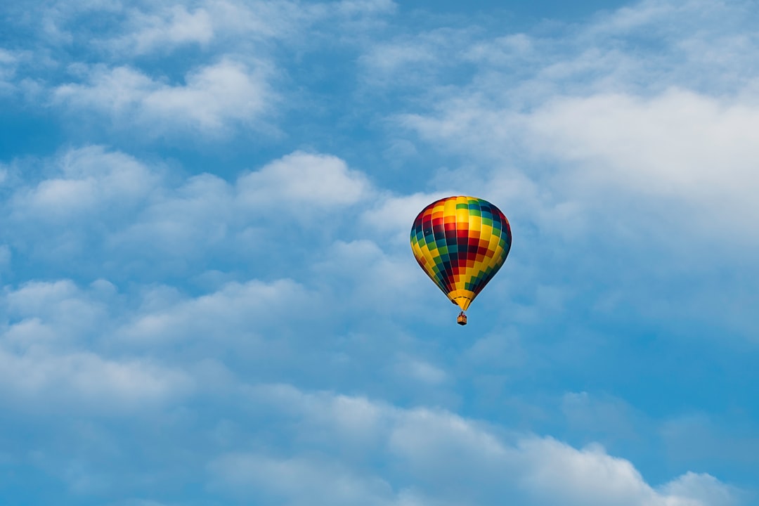 hot air balloon in mid air under cloudy sky during daytime