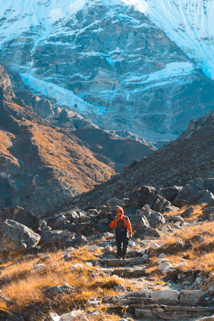 Outdoor scene showing a hiker using Exova trail product on a rugged mountain path.