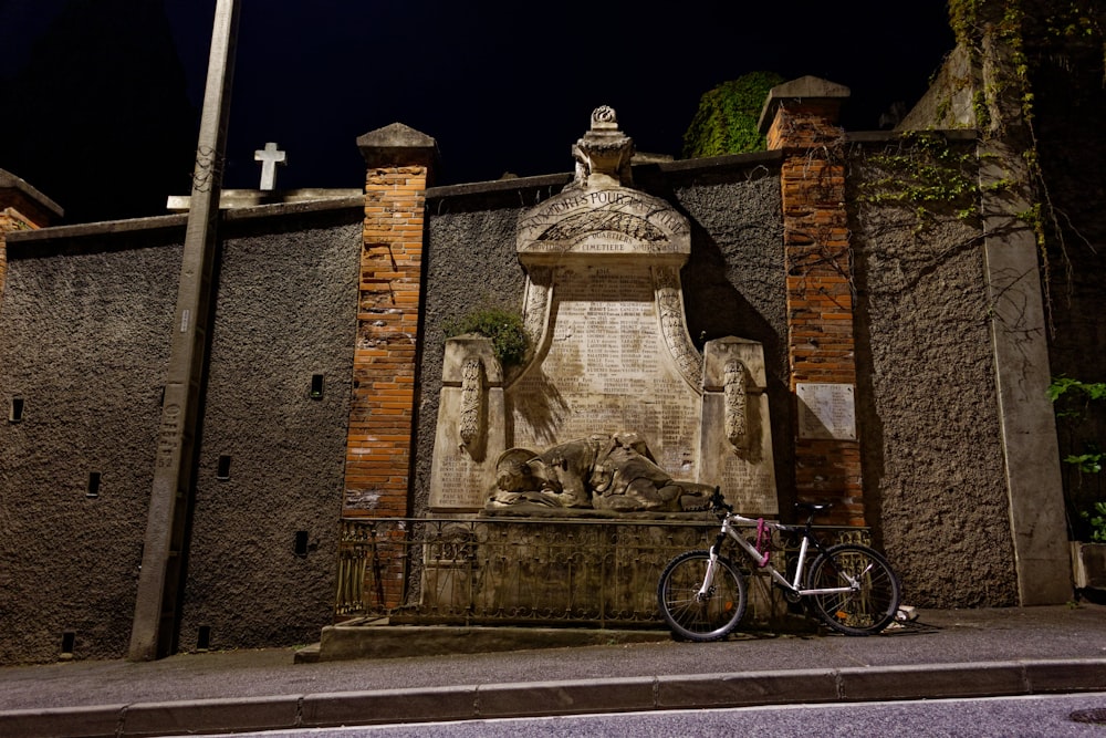 茶色のレンガ造りの建物の近くで自転車に乗る男の像