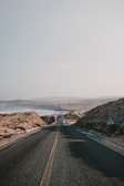 black asphalt road between brown mountains during daytime