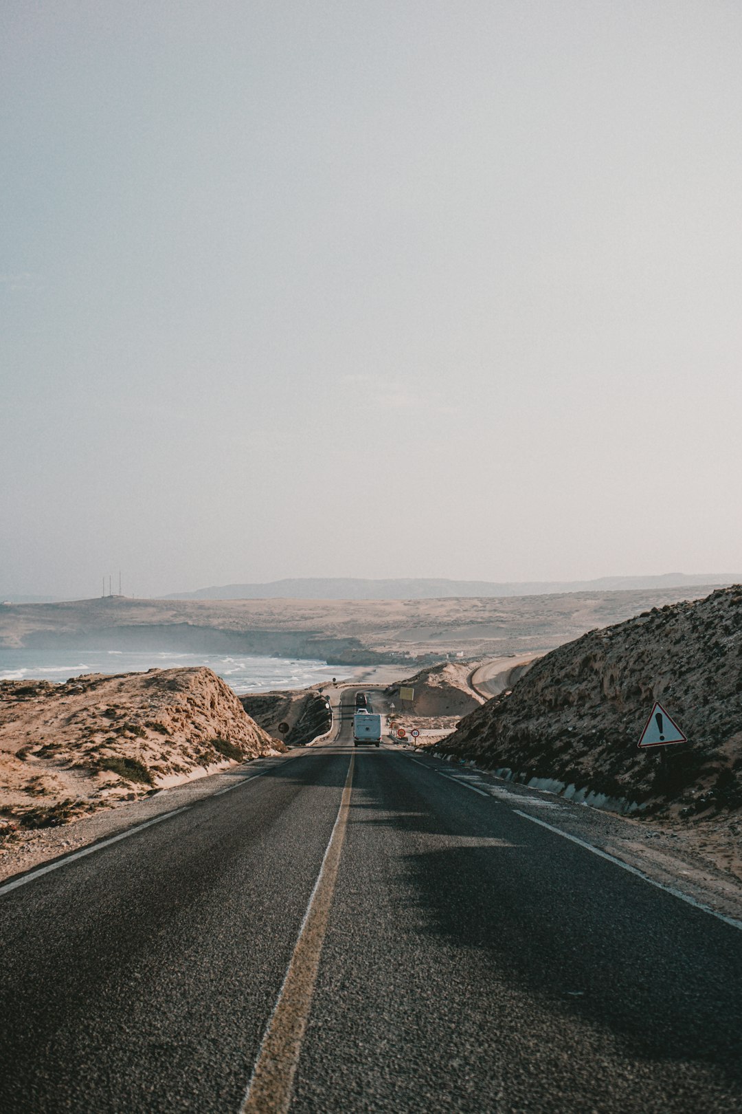 black asphalt road between brown mountains during daytime