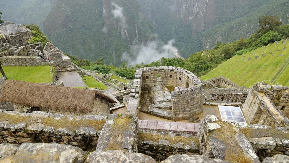 Bâtiment en béton brun sur un champ d’herbe verte pendant la journée