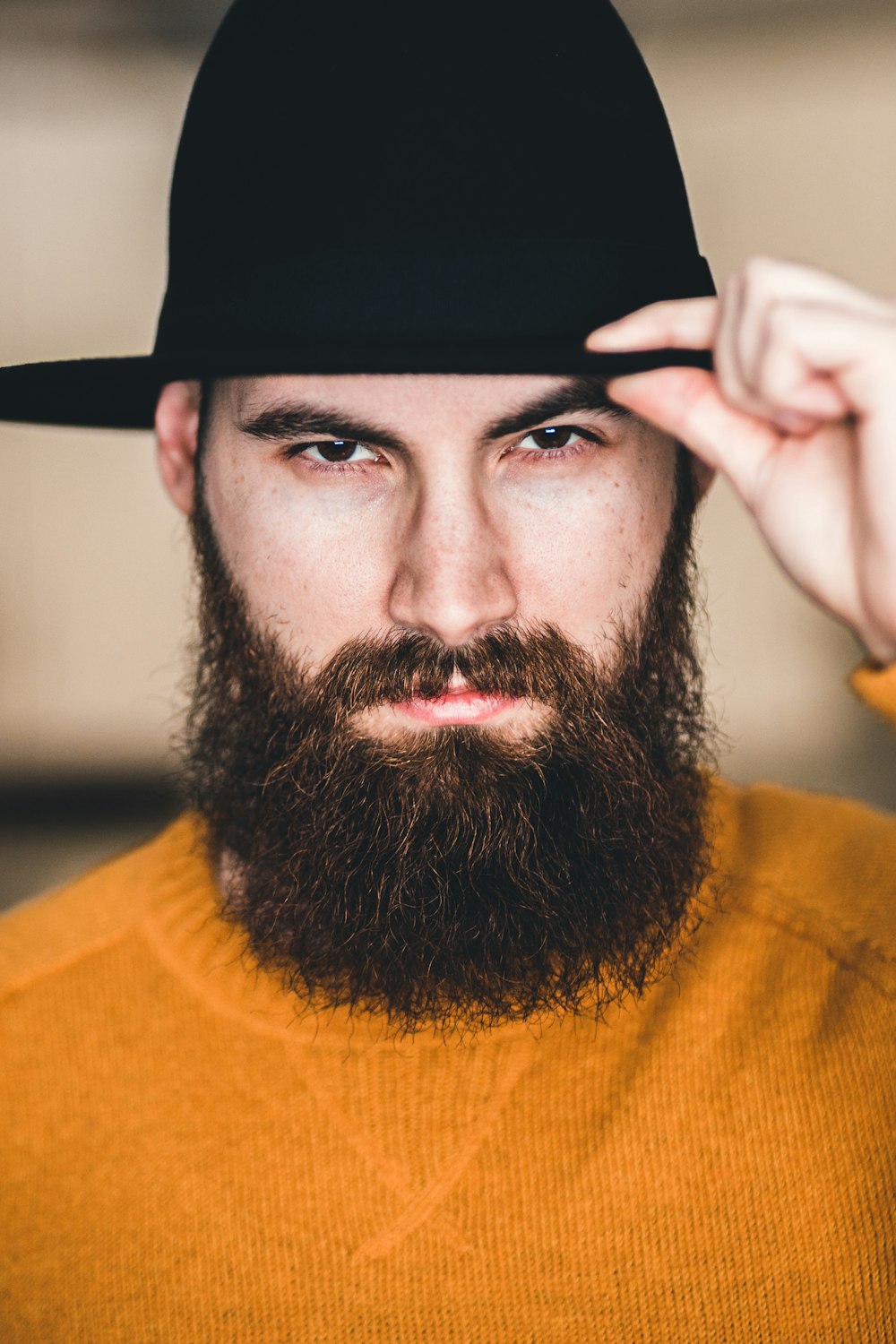 uomo in camicia girocollo gialla che indossa cappello nero