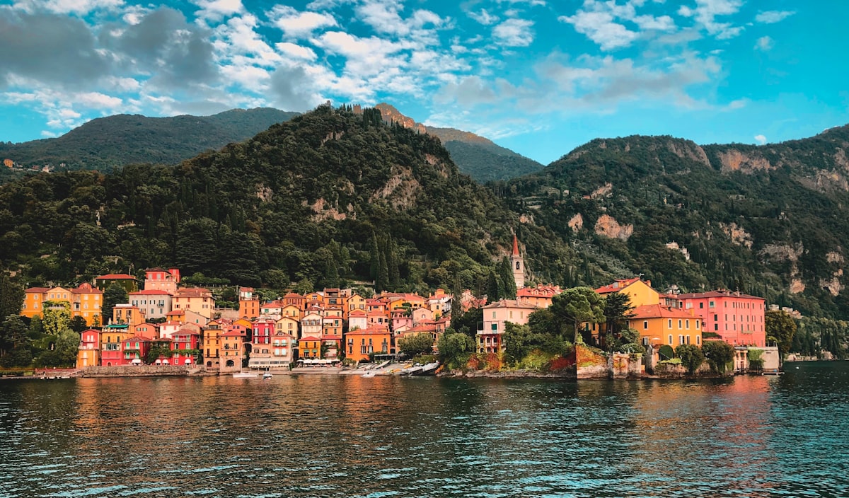 Lago di Como con ville e montagne riflesse nell'acqua in un pomeriggio estivo
