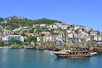 brown boat on body of water near city buildings during daytime