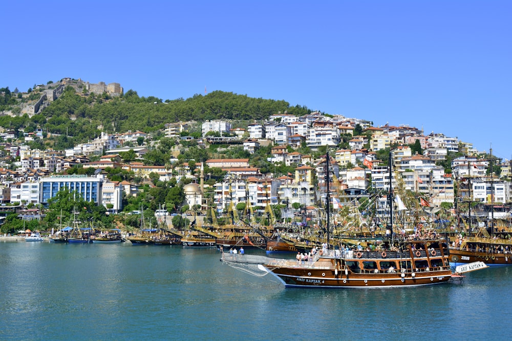 brown boat on body of water near city buildings during daytime