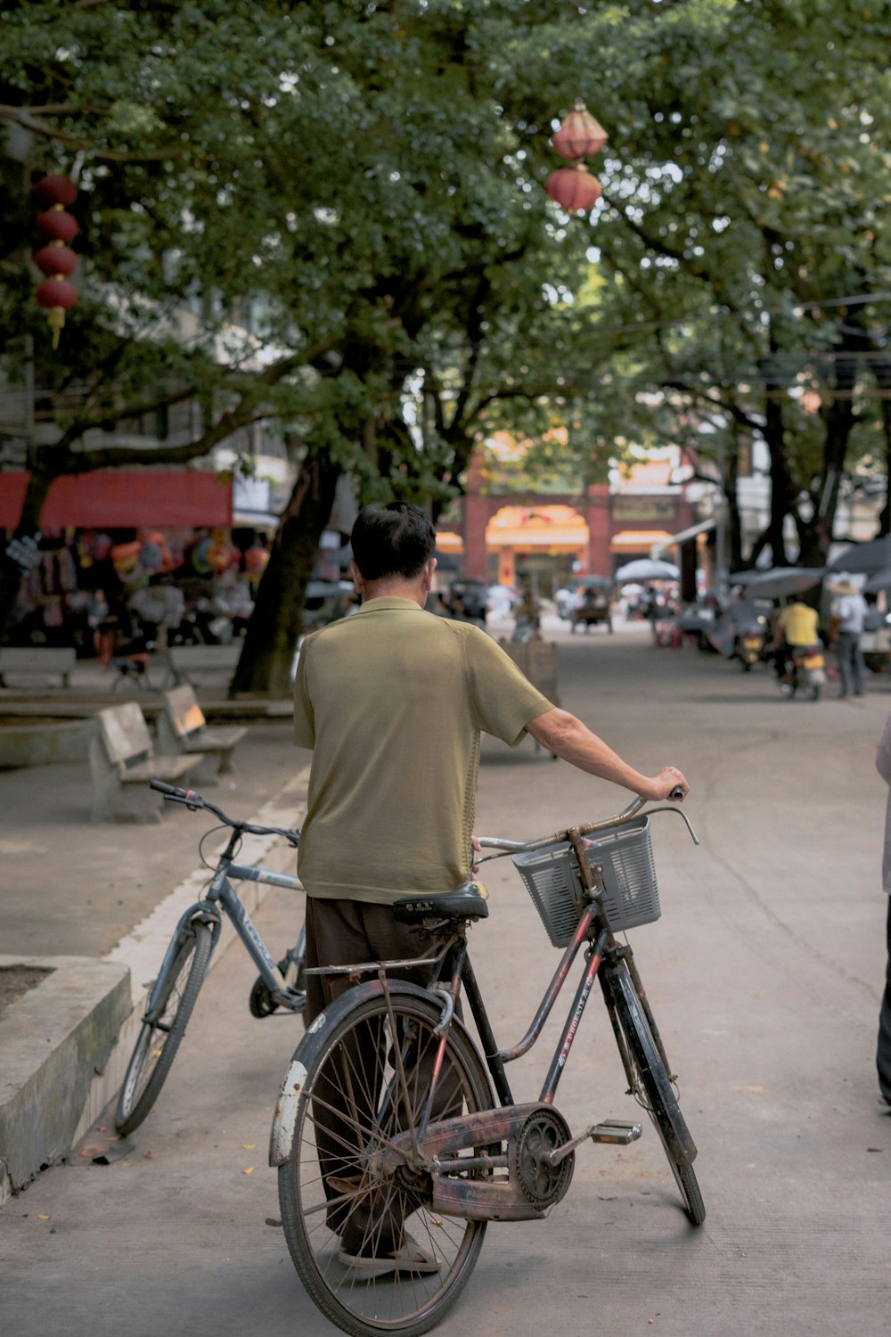 man in yellow shirt riding on bicycle during daytime