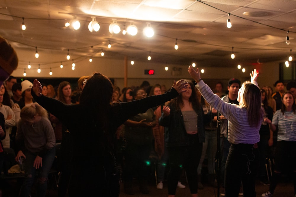 people standing and raising hands