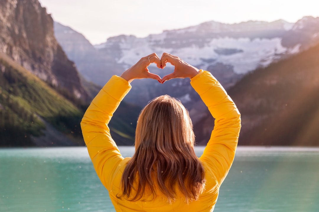 woman in yellow long sleeve shirt covering her face with her hands