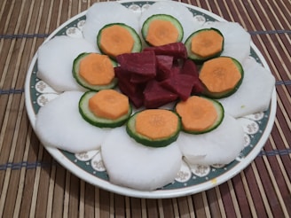 Fresh taro roots and sliced taro chips arranged on a natural fiber mat.