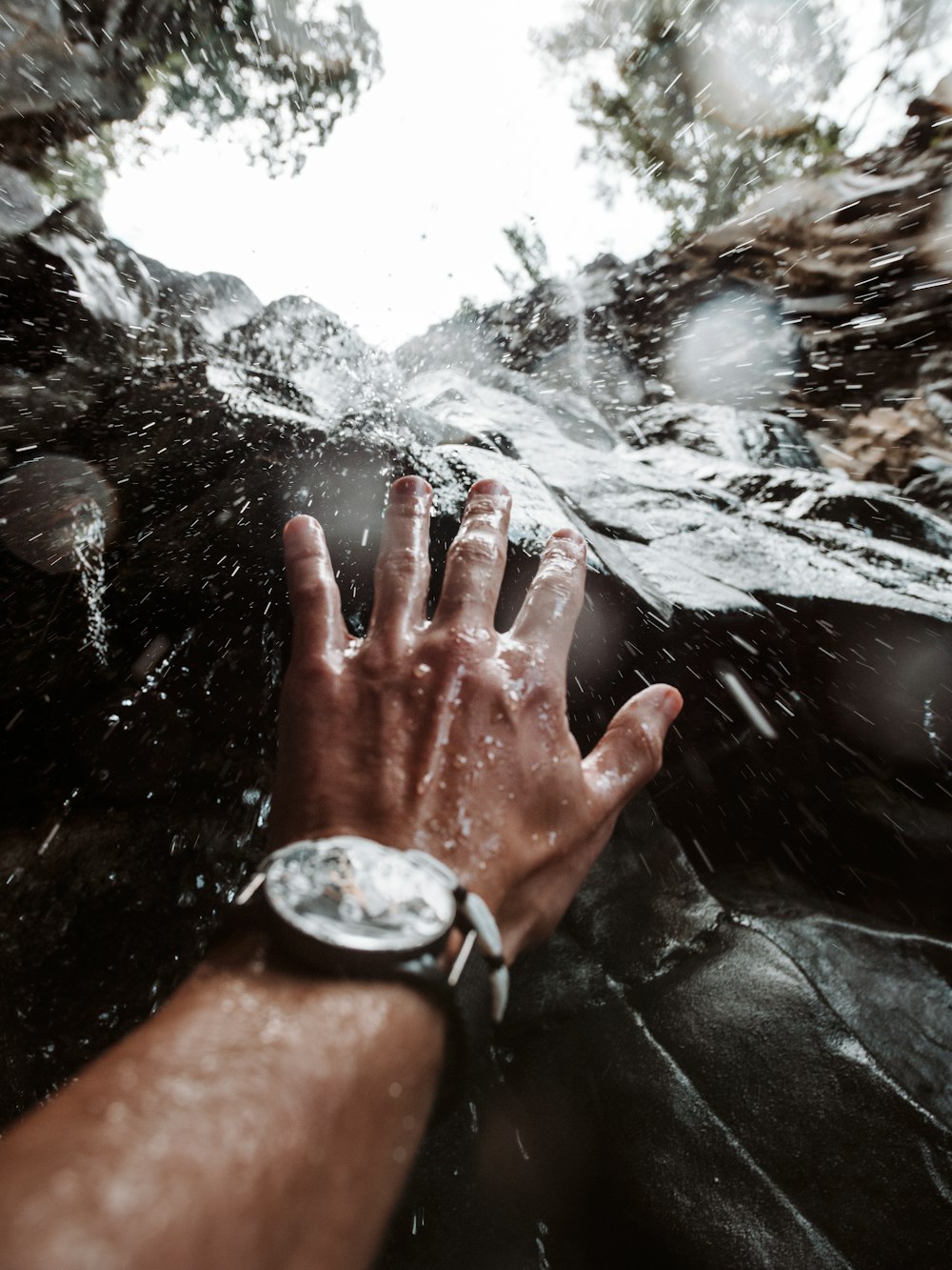 person wearing silver round analog watch with black leather strap