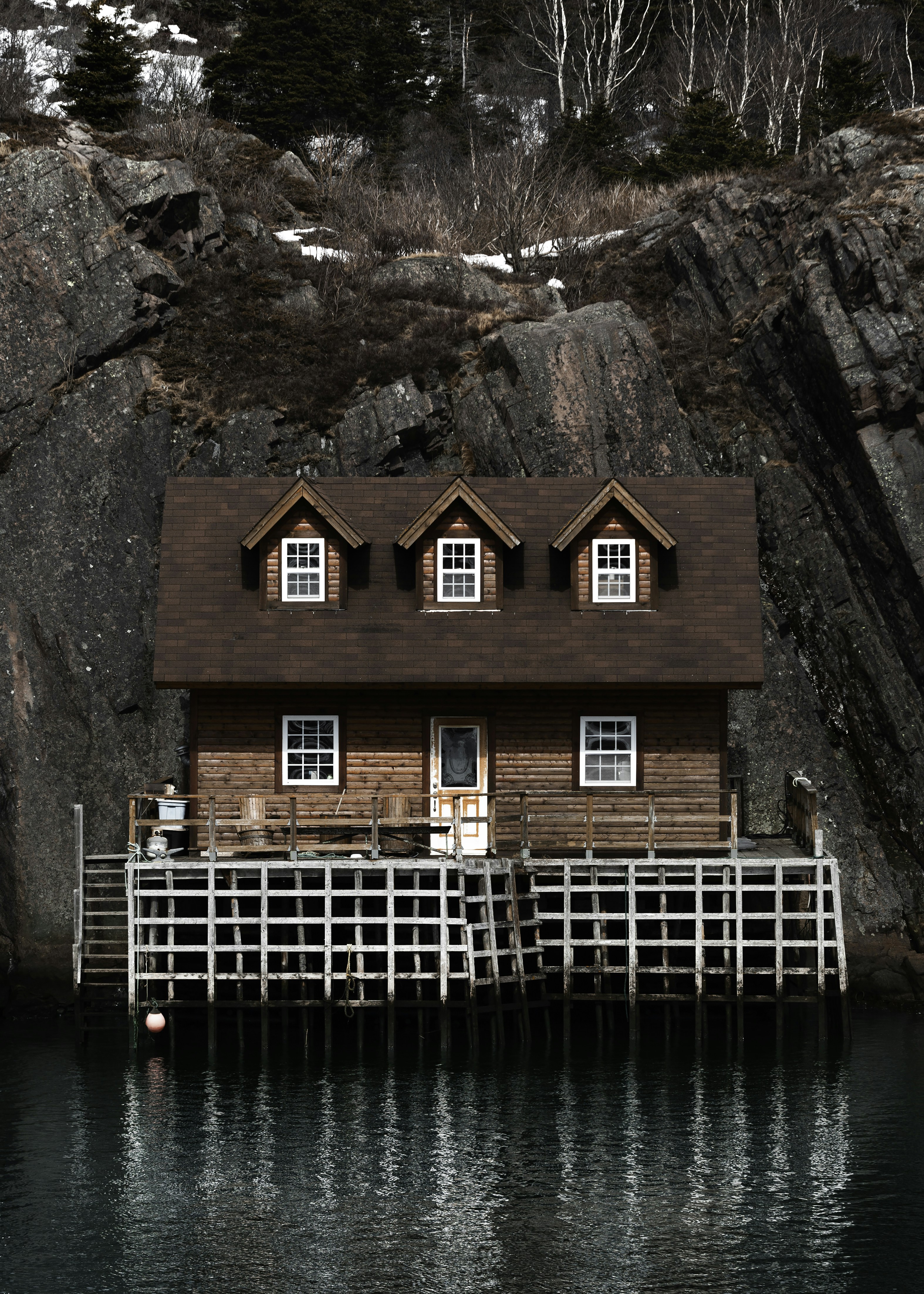 brown and red wooden house beside body of water