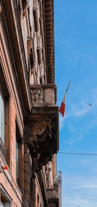 A detailed illustration of the Italian Parliament building in Rome under a clear sky.