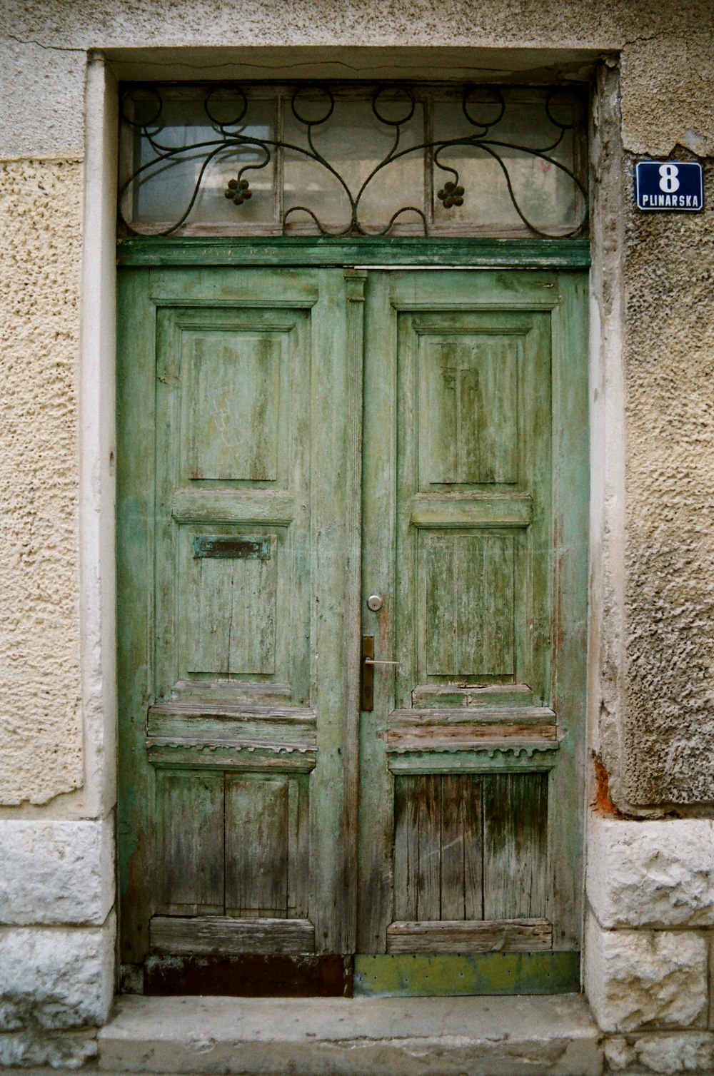 blue wooden door on white concrete wall