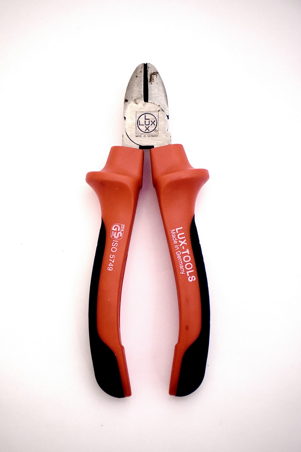 a pair of red and black pliers on a white background