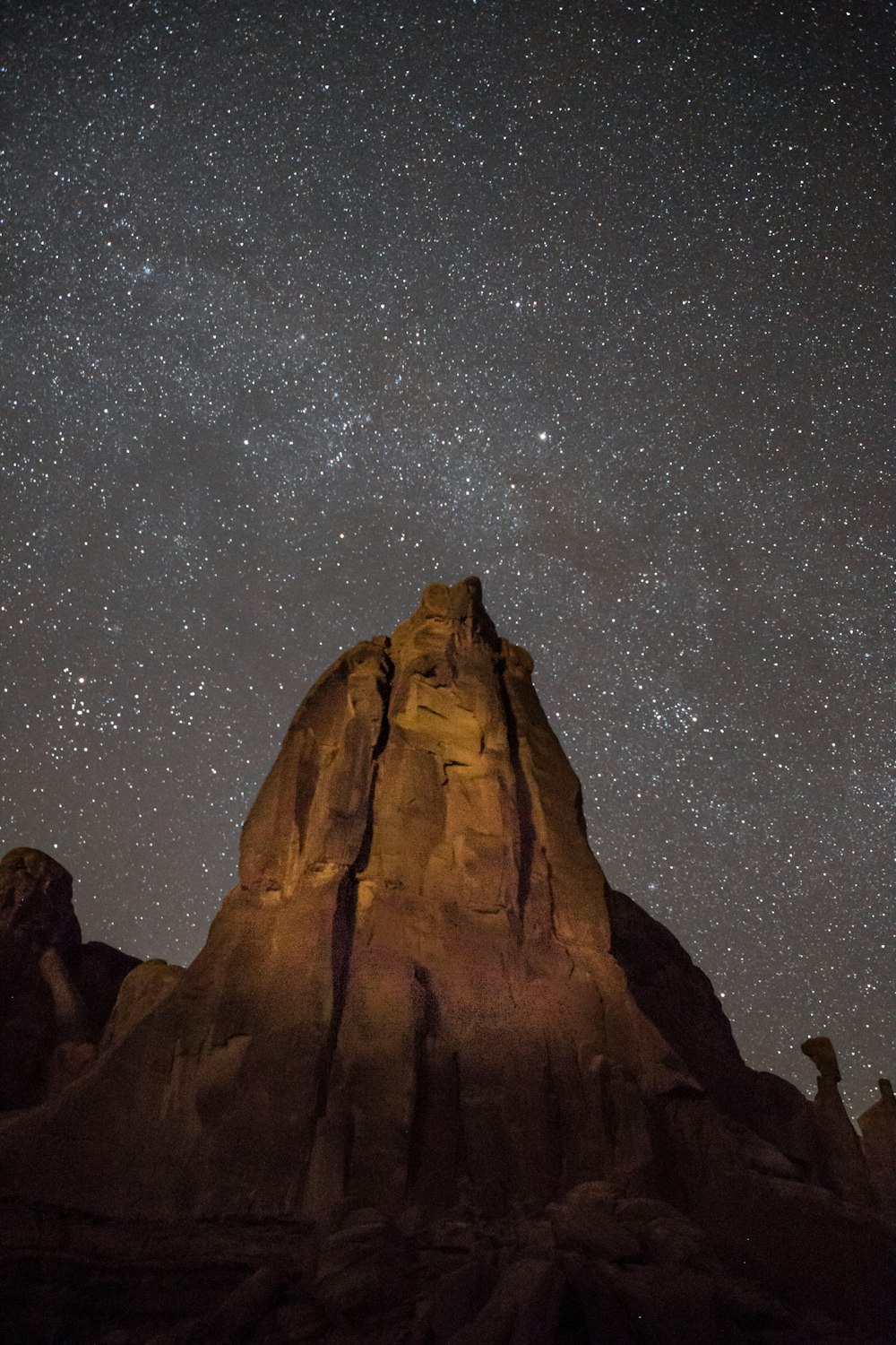 brown rock formation under starry night