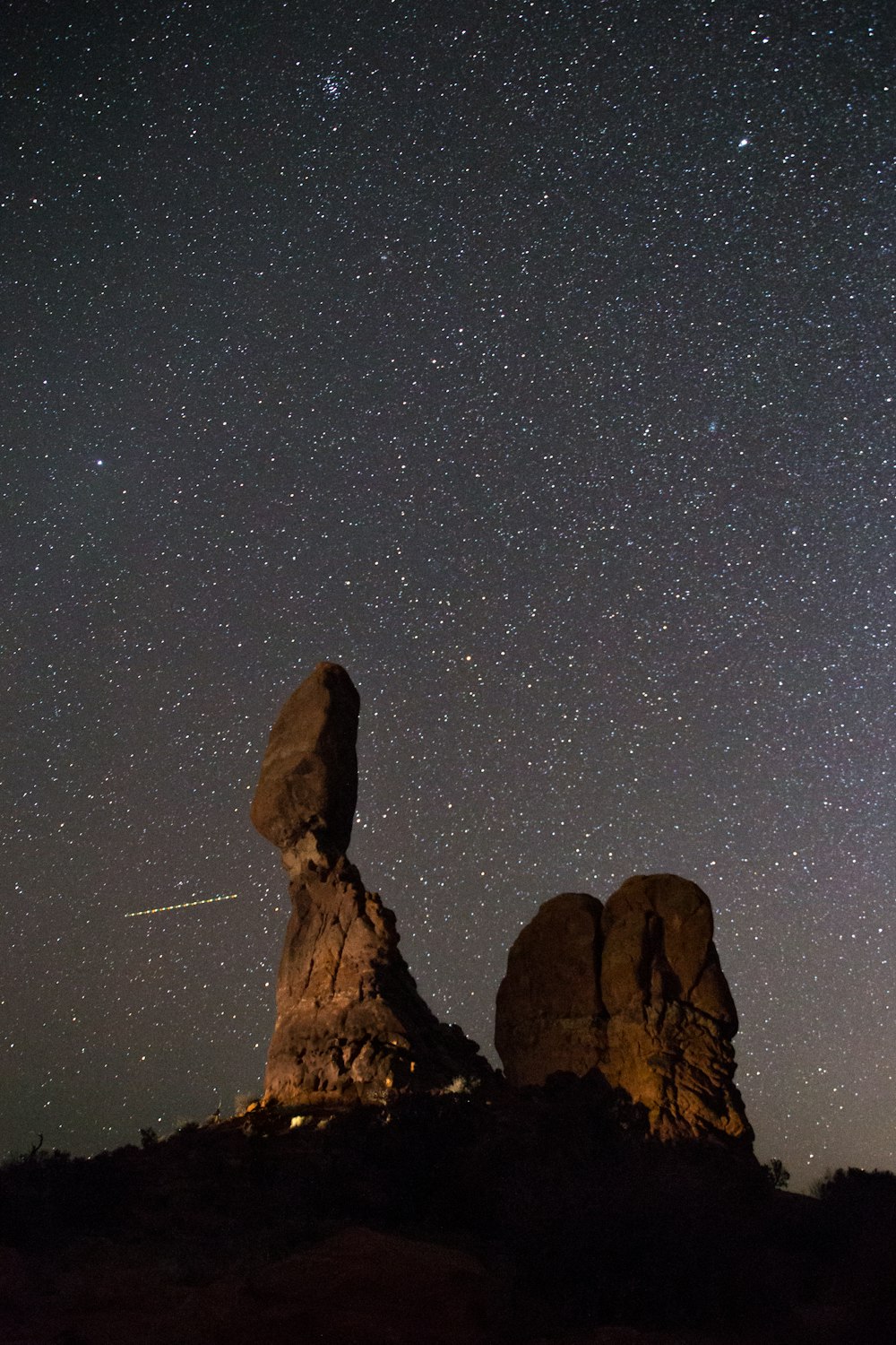 brown rock formation under starry night