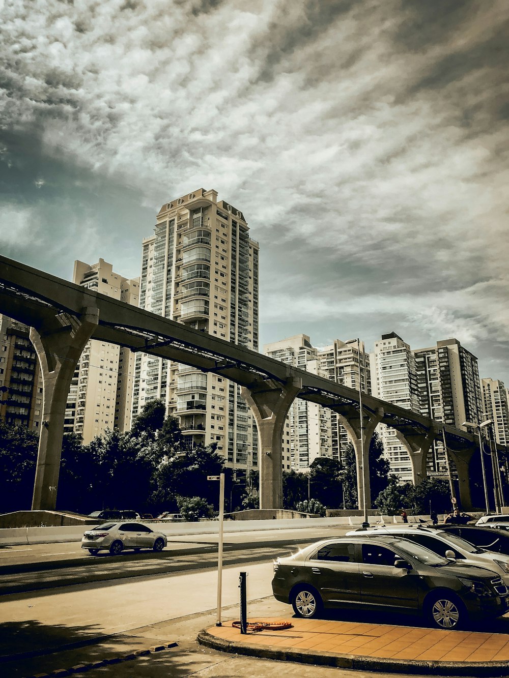 cars parked on parking lot near high rise buildings during daytime