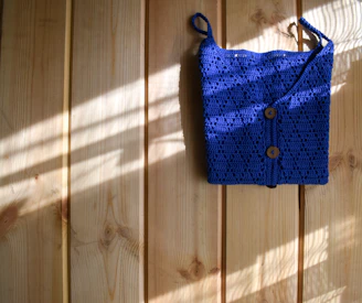 A stylish tote bag made from durable fabric hanging on a rustic hook by a sunny window.