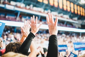 Close-up of hands raised during a public forum promoting personal choice and rights.