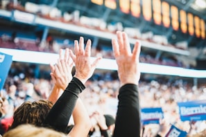 Close-up of hands raising signs with messages encouraging voter participation.