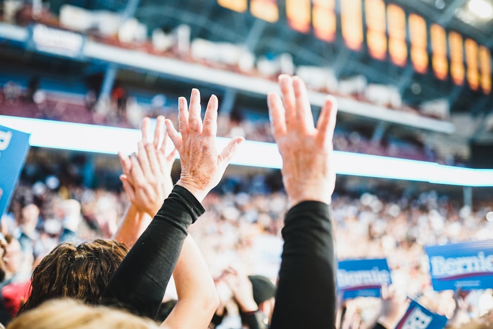 person in black long sleeve shirt raising hands