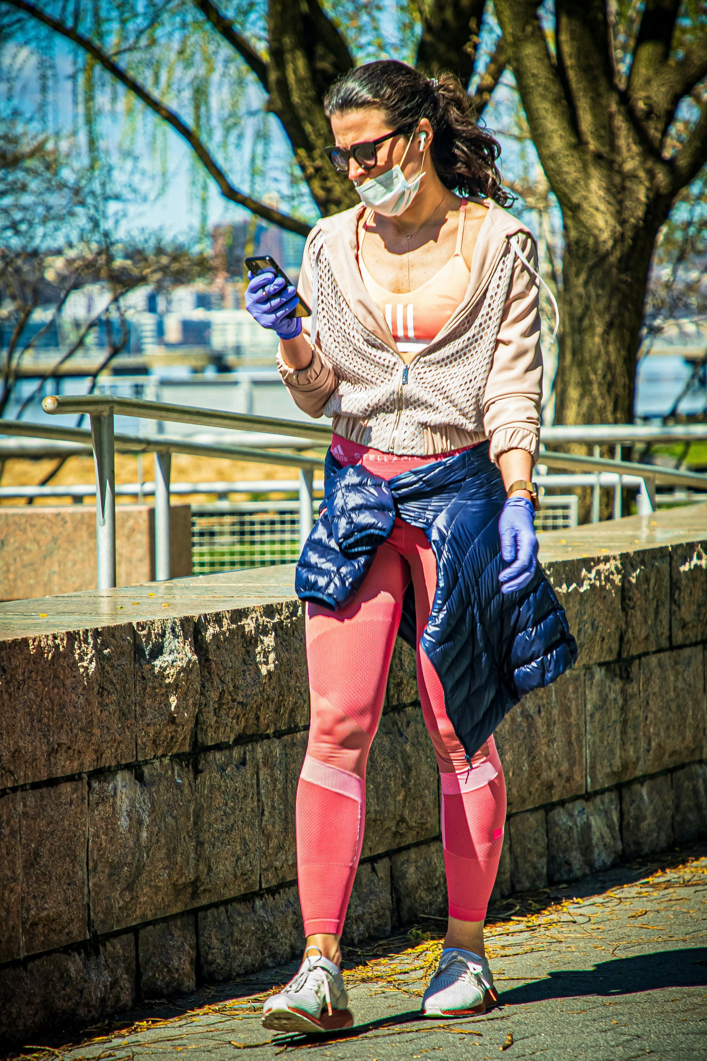woman in white and brown striped long sleeve shirt and blue denim skirt sitting on concrete