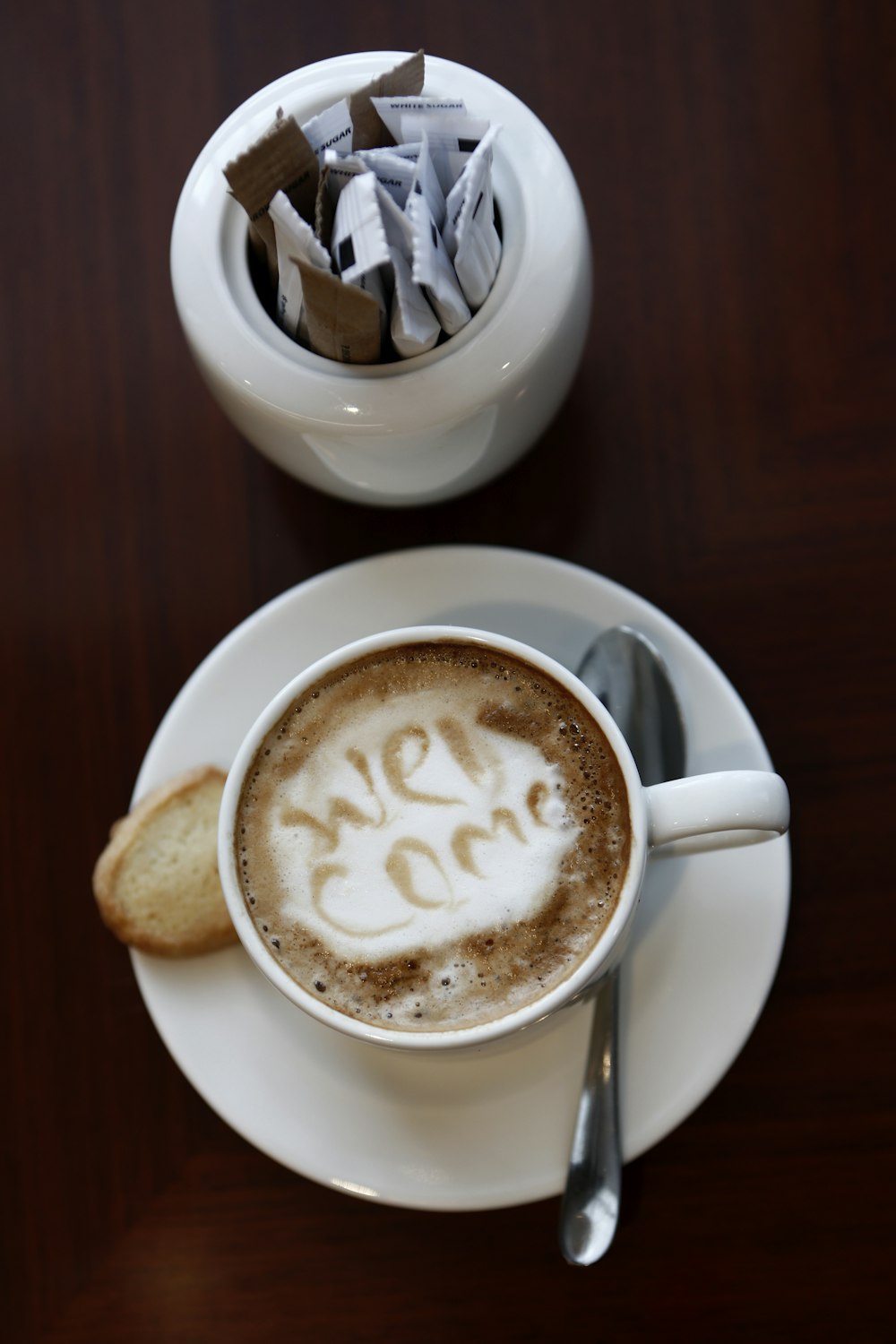 white ceramic cup with saucer on brown wooden table