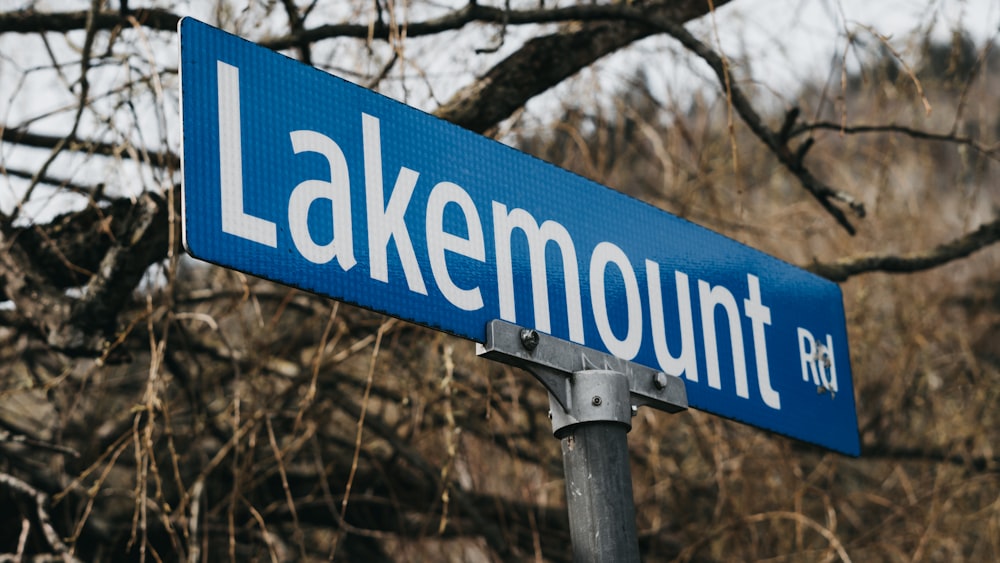 a close up of a street sign with trees in the background