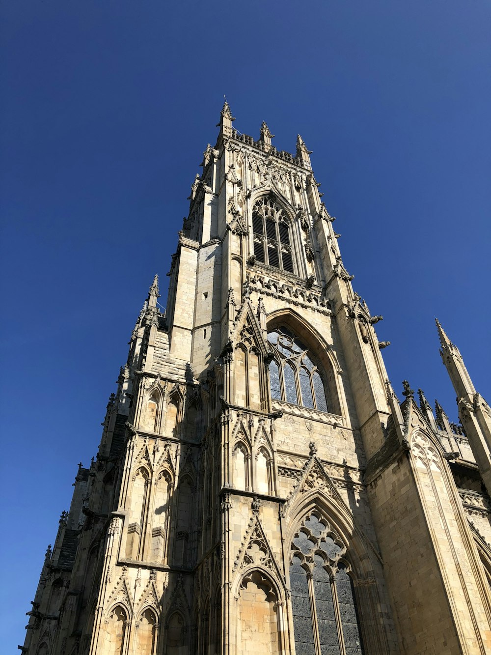 fotografia ad angolo basso dell'edificio in cemento marrone sotto il cielo blu durante il giorno