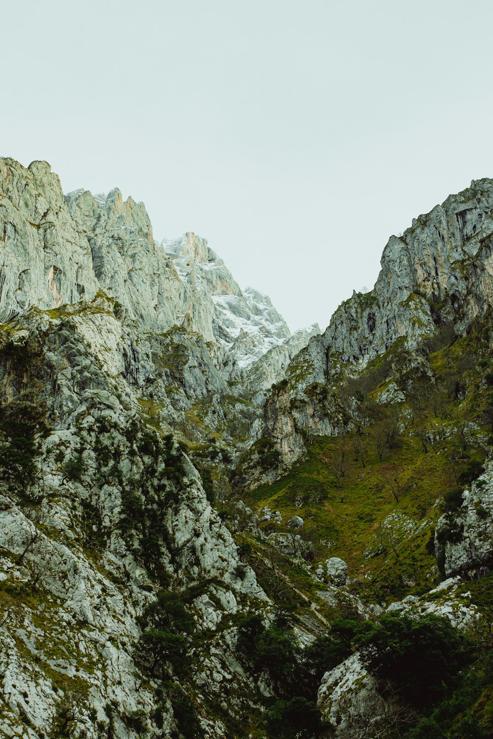 montagna rocciosa grigia sotto il cielo bianco durante il giorno