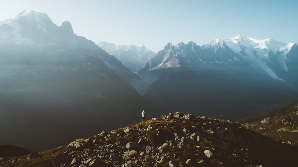 person standing on rocky mountain during daytime