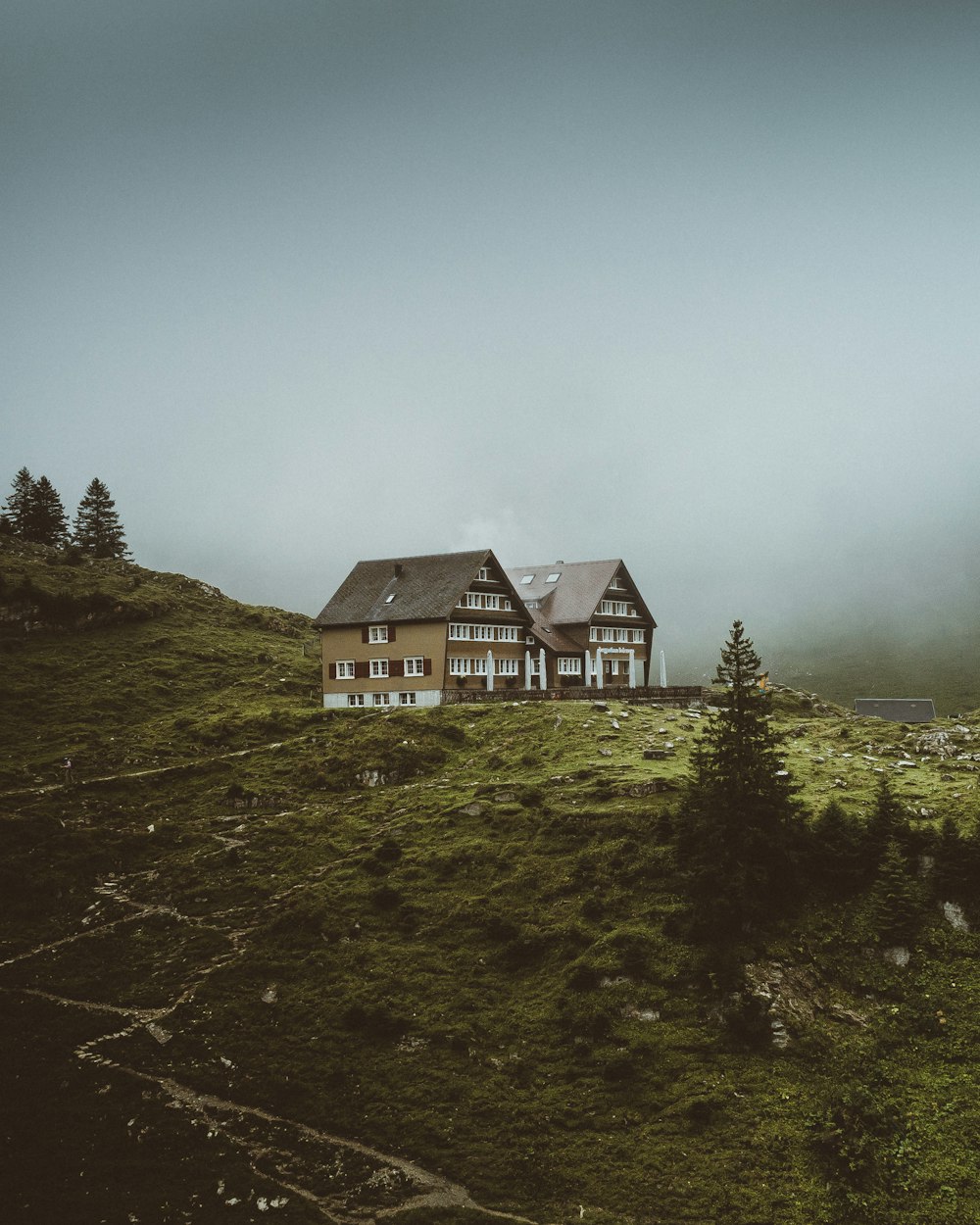 white and black house on green grass field under gray sky