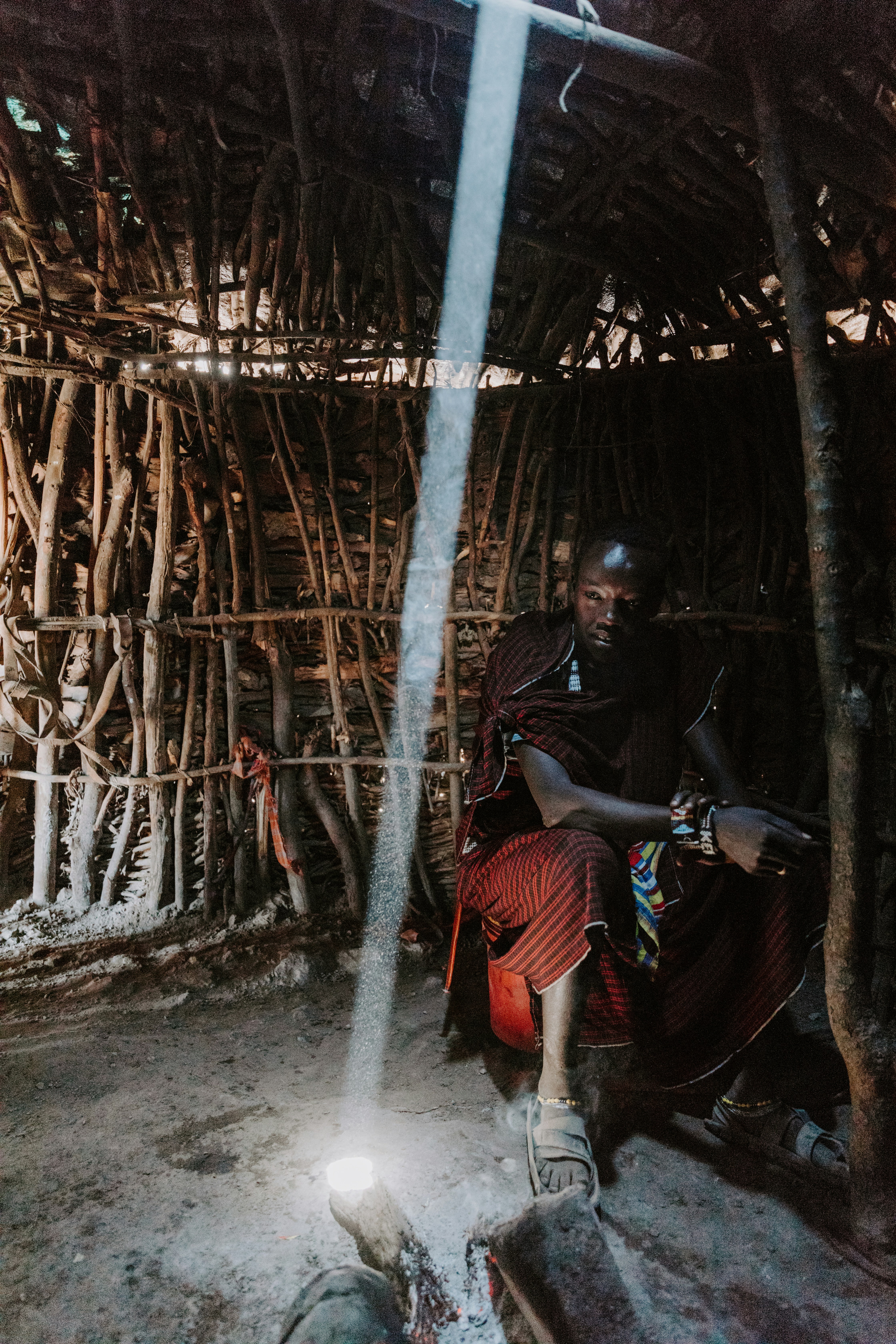 Hombre en chaqueta negra y pantalones naranjas sentado en hamaca